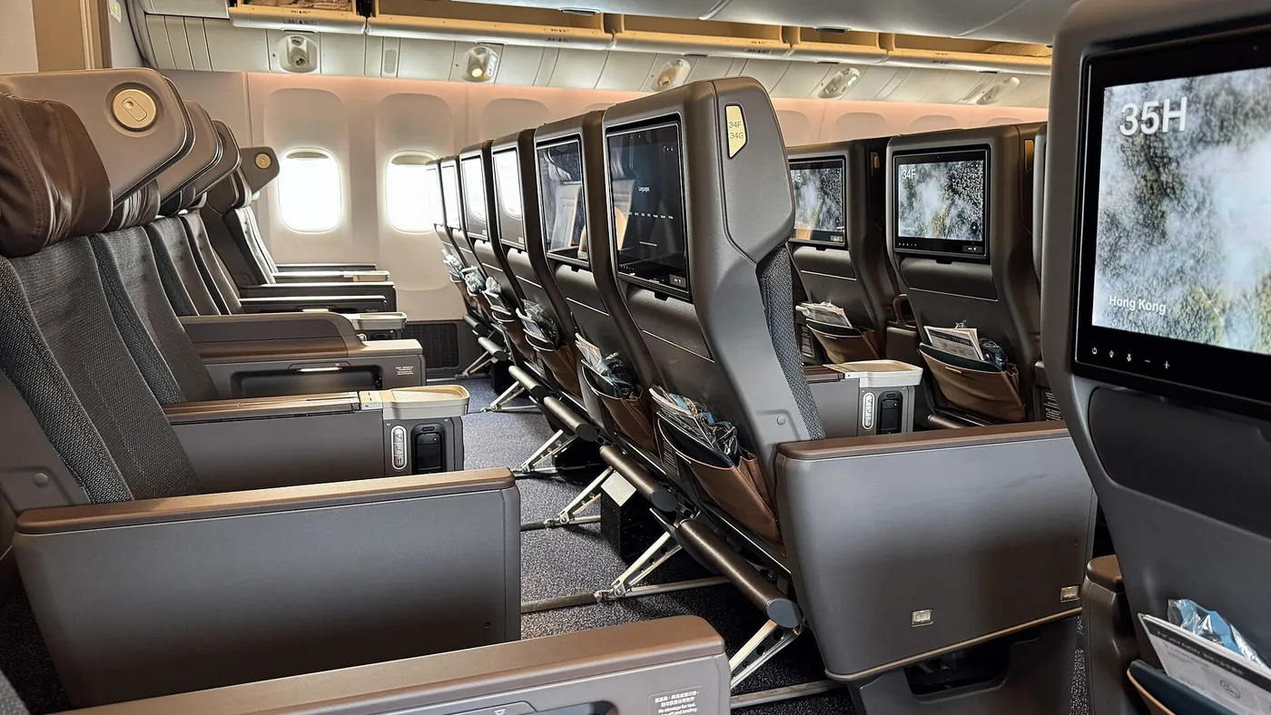 Cabine de classe premium economy em um Boeing 777-300ER, com poltronas mais largas e telas individuais