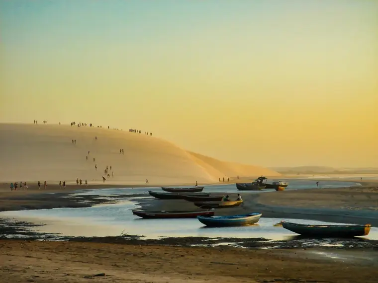 Duna do pôr do sol em Jericoacoara com jangadas na praia ao entardecer