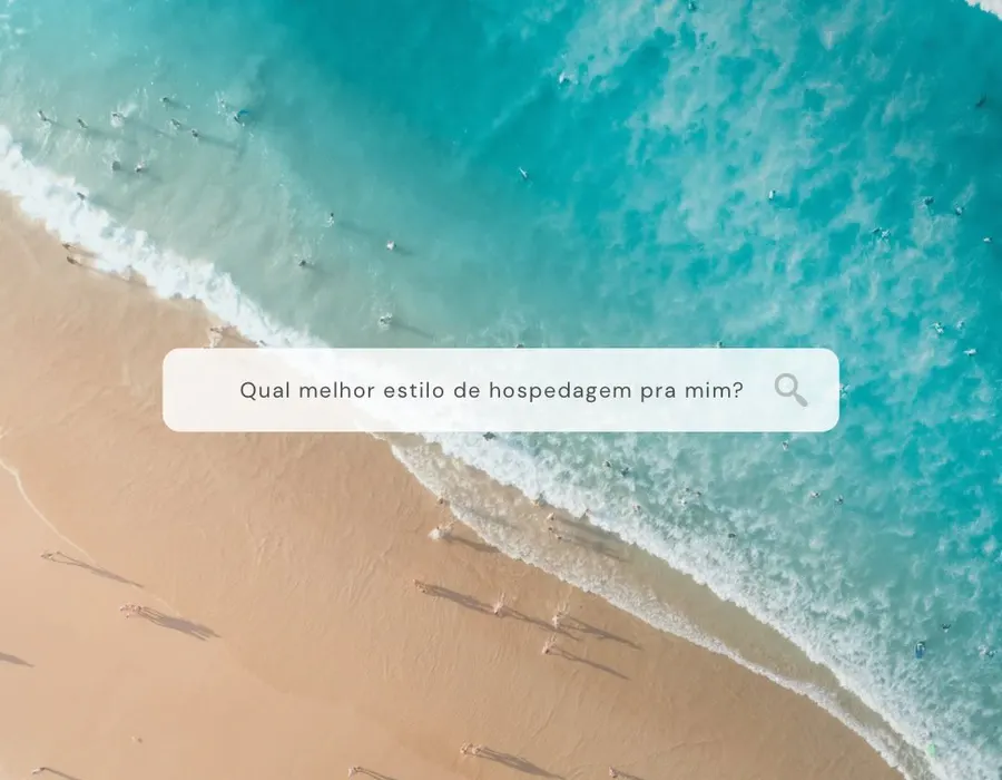 Vista aérea de praia de areia branca com mar verde cristalino e piscinas naturais