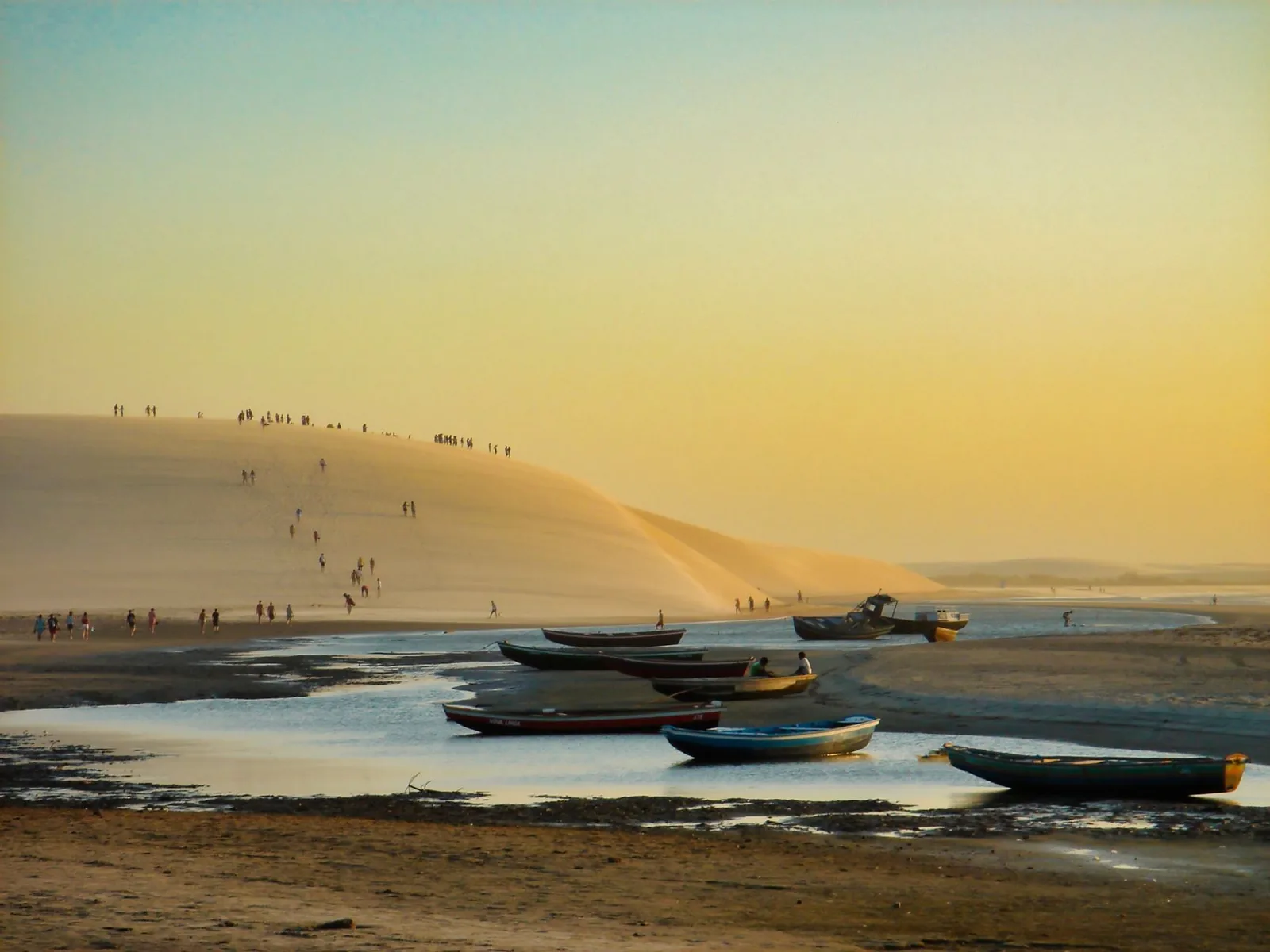 Duna do Pôr do Sol em Jericoacoara com barcos coloridos na areia ao entardecer