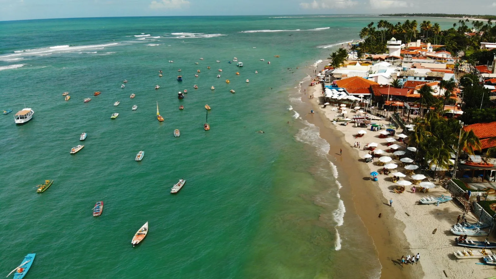 Vista aérea de Porto de Galinhas com jangadas ancoradas sobre as piscinas naturais